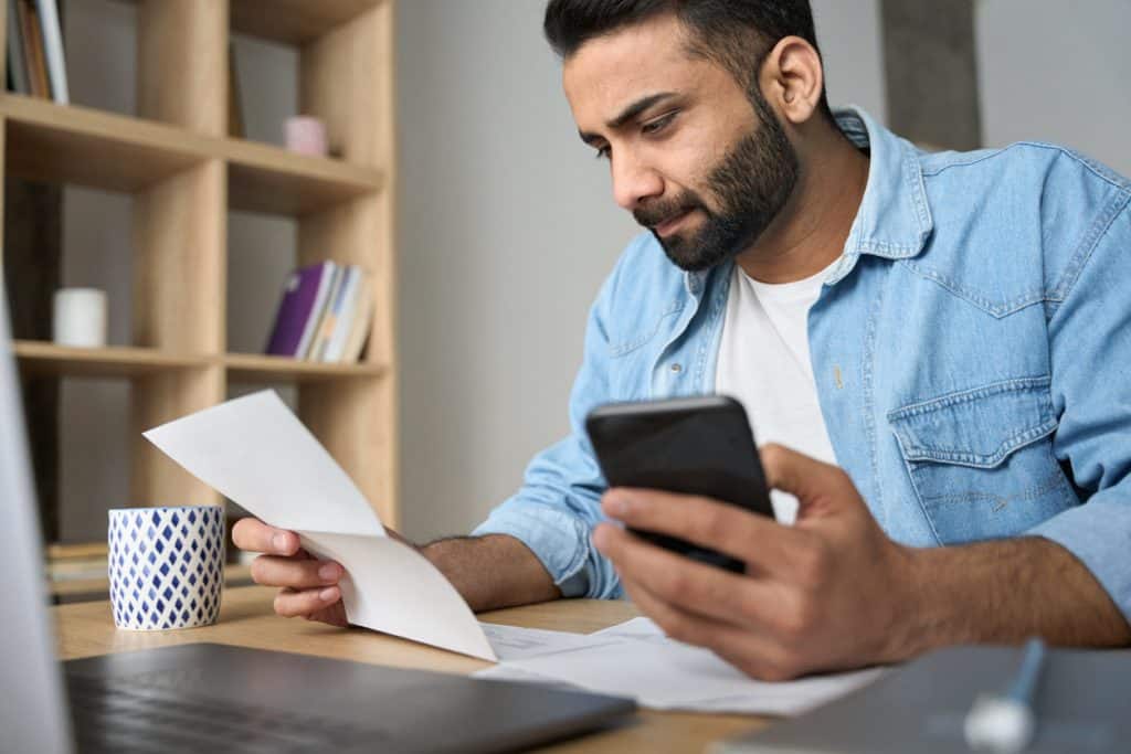 Man using Astropay on his phone to pay for online sports betting in India